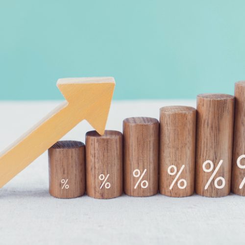 Wooden blocks with percentage sign and arrow up, financial growth, interest rate and mortgage rate increase, inflation concept